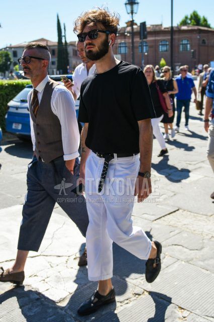 A summer men's coordinate outfit with plain black sunglasses, a plain black T-shirt, a plain black leather belt, plain white cotton pants, and black leather sandals.