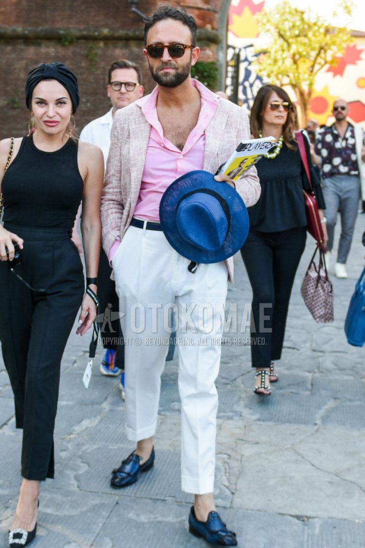 Spring and summer men's coordinate outfit with brown tortoiseshell sunglasses, plain pink tailored jacket, plain pink shirt, plain black leather belt, plain white cotton pants, and black other loafer leather shoes.
