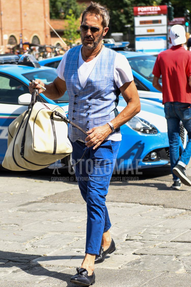 Summer men's coordinate outfit with plain silver sunglasses, plain white T-shirt, light blue checked gilet, plain blue cotton pants, black bit loafer leather shoes, and plain white Boston bag.