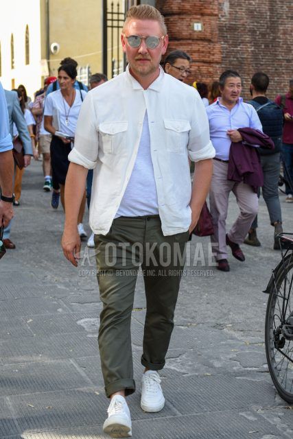 A summer men's coordinate outfit with plain silver sunglasses from Boston, a plain white shirt, a plain white t-shirt, plain olive green cotton pants, and white low-cut sneakers.