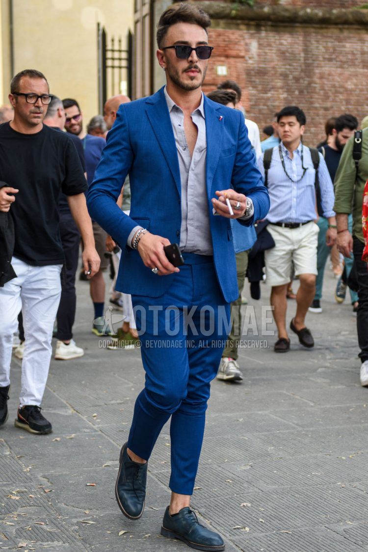 A square plain black sunglasses, plain gray shirt, blue plain toe leather shoes, and plain blue suit for men's spring, summer, and fall outfits.