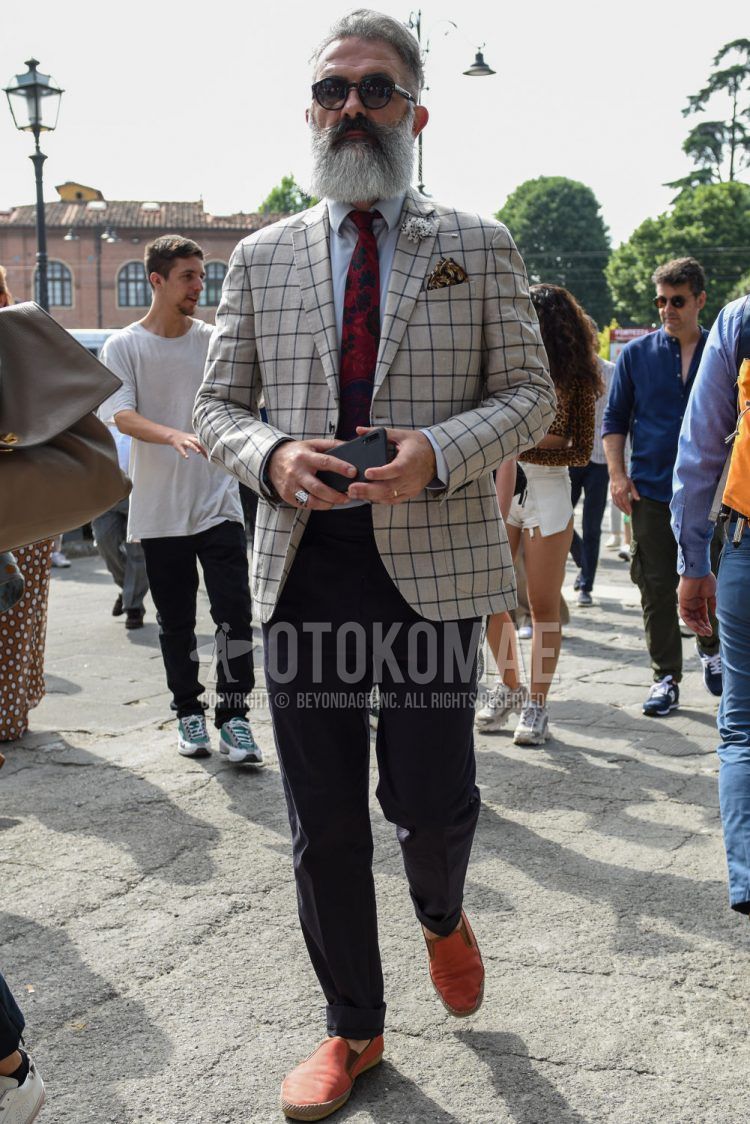 Spring, summer and fall men's coordinate outfit with plain black sunglasses, beige/gray checked tailored jacket, plain white shirt, plain black other, orange slip-on sneakers and red other tie.