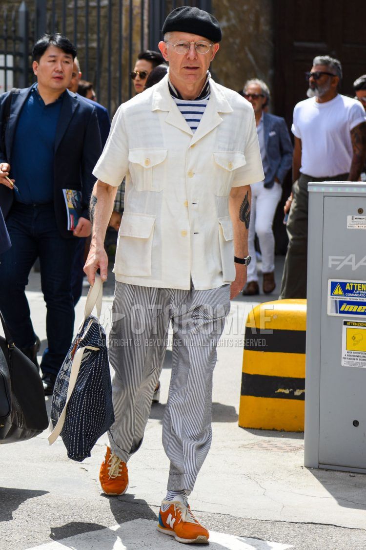 Other solid black, solid silver glasses, white/blue striped inner down, open collar solid white shirt, solid gray wide pants, solid gray slacks, white/black striped socks, New Balance orange low cut sneakers, navy striped A summer men's coordinate outfit with a navy striped tote bag.