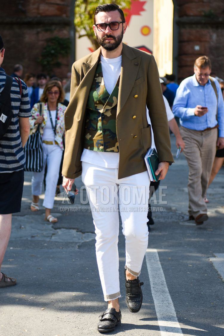Spring, summer and fall men's coordinate outfit with plain black sunglasses, plain olive green tailored jacket, multi-colored camouflage gilet, plain white T-shirt, plain white ankle pants and black monk shoe leather shoes.