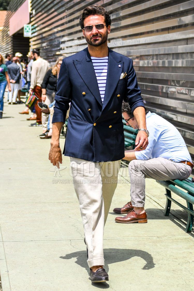 Summer-spring-fall men's coordinate outfit with plain sunglasses, plain navy tailored jacket, white-navy striped T-shirt, plain beige slacks, and brown coin loafer leather shoes.