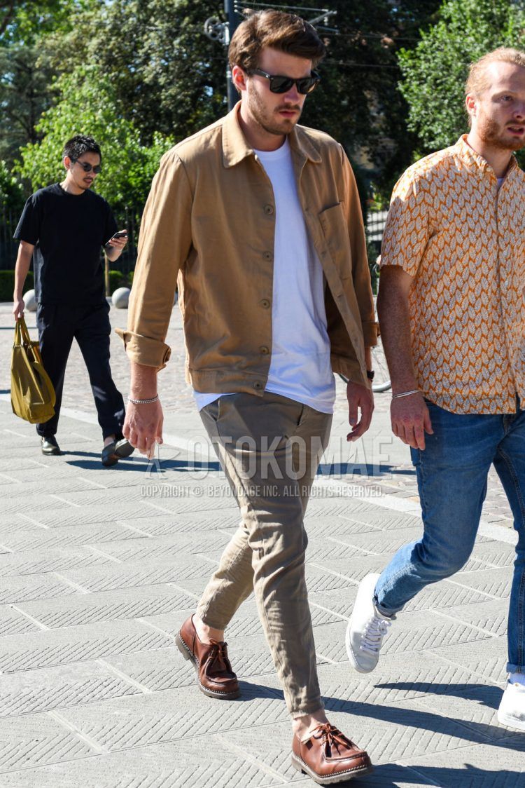 Spring and fall men's coordinate outfit with plain black Wellington sunglasses, plain beige shirt jacket, plain white t-shirt, plain beige chinos, and brown and other leather shoes from Paraboots.