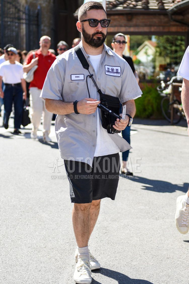 A summer men's coordinate outfit with plain black sunglasses, a short-sleeved plain gray shirt, a plain white T-shirt, plain black shorts, plain white socks, white low-cut sneakers, and a plain black sackosh.
