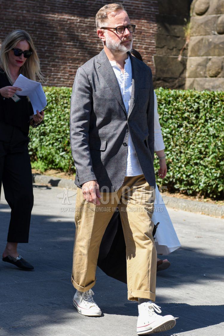 Spring, summer, and fall men's coordinate outfit with plain black/brown glasses, plain gray tailored jacket, collarless plain white shirt, plain beige wide pants, plain gray socks, and white high-cut Converse sneakers.