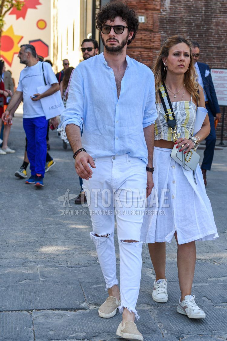 Spring, fall and summer men's coordinate outfit with Wellington plain black sunglasses, plain light blue shirt, plain white slacks and beige slip-on sneakers.