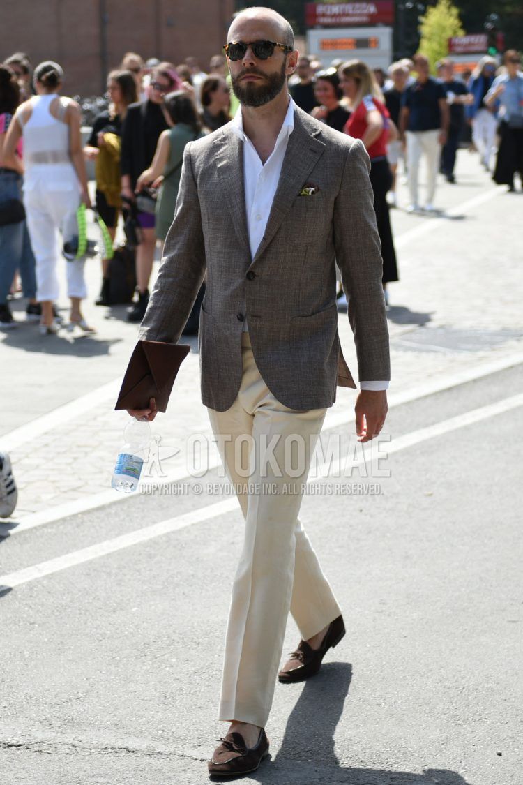 Spring and fall men's coordinate outfit with black tortoiseshell sunglasses, plain brown/gray tailored jacket, plain white shirt, plain white slacks, and brown tassel loafer leather shoes.