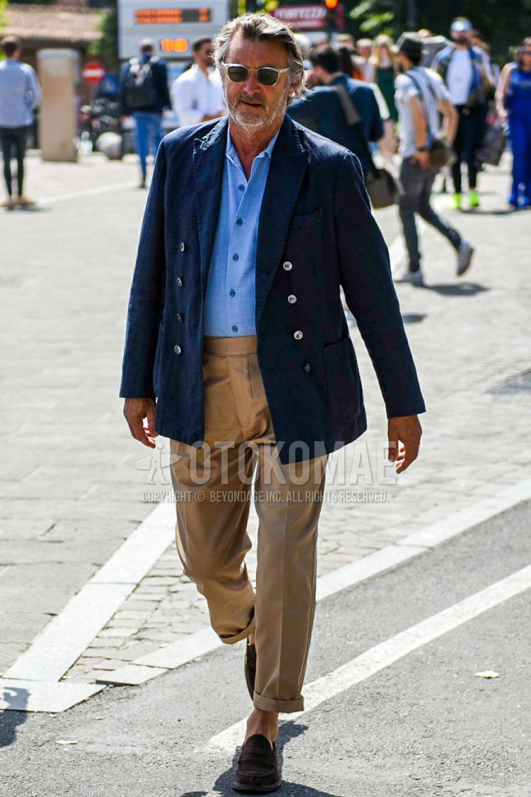 Spring, summer and fall men's coordinate outfit with clear solid color sunglasses, navy solid color tailored jacket, light blue solid color shirt, brown solid color beltless pants and brown coin loafer leather shoes.