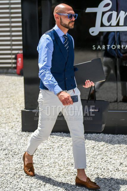 Men's fall/summer/spring outfit with solid blue sunglasses, solid navy gilet, solid light blue shirt, solid white cotton pants, and navy regimental tie.