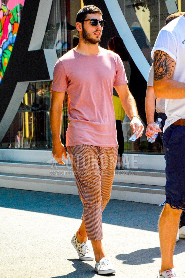 A men's spring/summer coordinate outfit with plain sunglasses, a plain pink t-shirt, pink checked cotton pants, and white low-cut sneakers.
