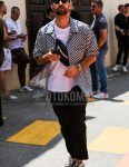 Summer men's coordinate outfit with plain black sunglasses, short sleeve black/white other shirt, short sleeve plain white t-shirt, plain black ankle pants, plain slacks, Converse All Star black low-cut sneakers, and A.P.C Arpesey plain black sackosh.