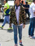 A spring/summer men's coordinate outfit with clear solid color sunglasses, navy and other bandana/neckerchief, beige camouflage shirt, white one-pointed t-shirt, blue solid color denim/jeans, white solid color socks, and blue, green and white low-cut sneakers.