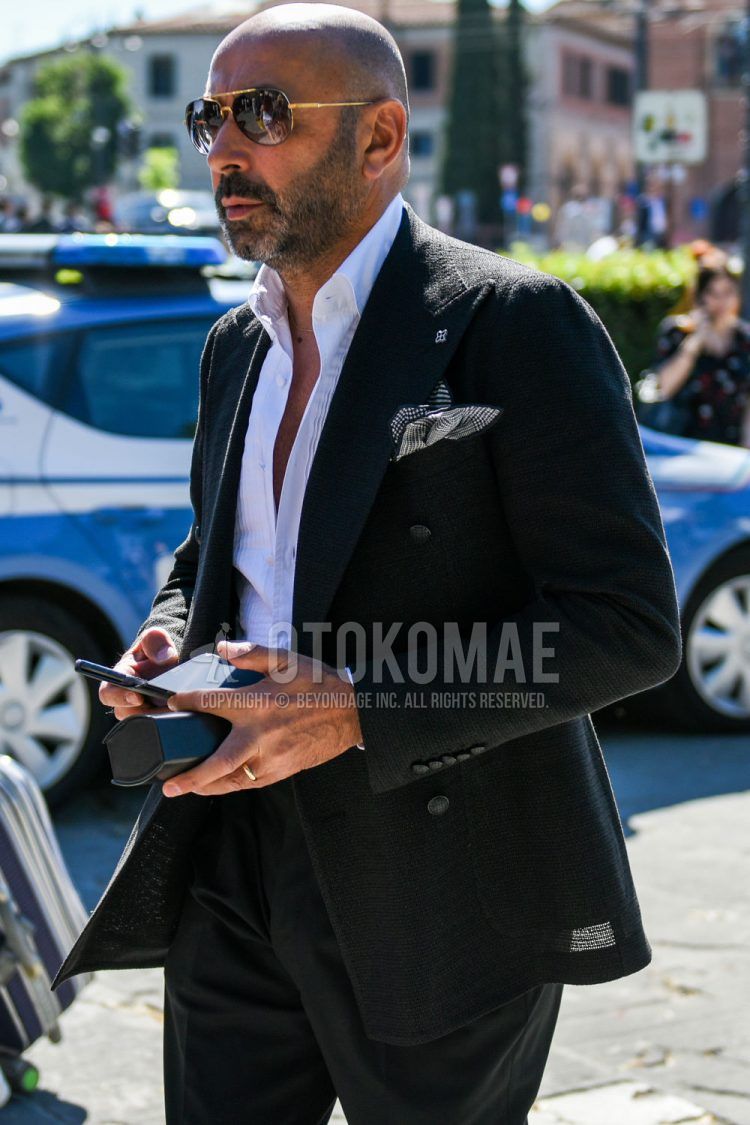 Teardrop black and gold plain sunglasses, plain black tailored jacket by Tagliatore, white striped shirt, and plain black slacks for men's spring, summer, and fall outfits.