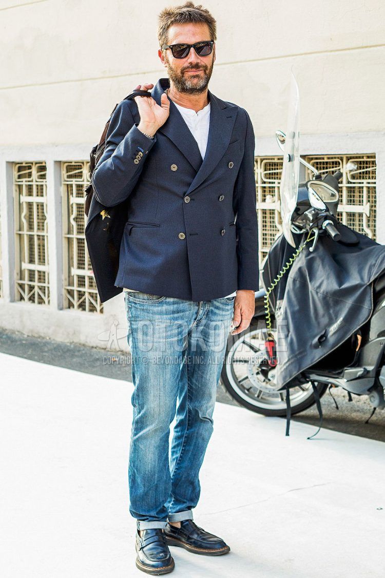 Spring and fall men's coordinate outfit with plain sunglasses, plain navy tailored jacket, plain white t-shirt with henley neck, plain blue denim/jeans, and black coin loafer leather shoes.