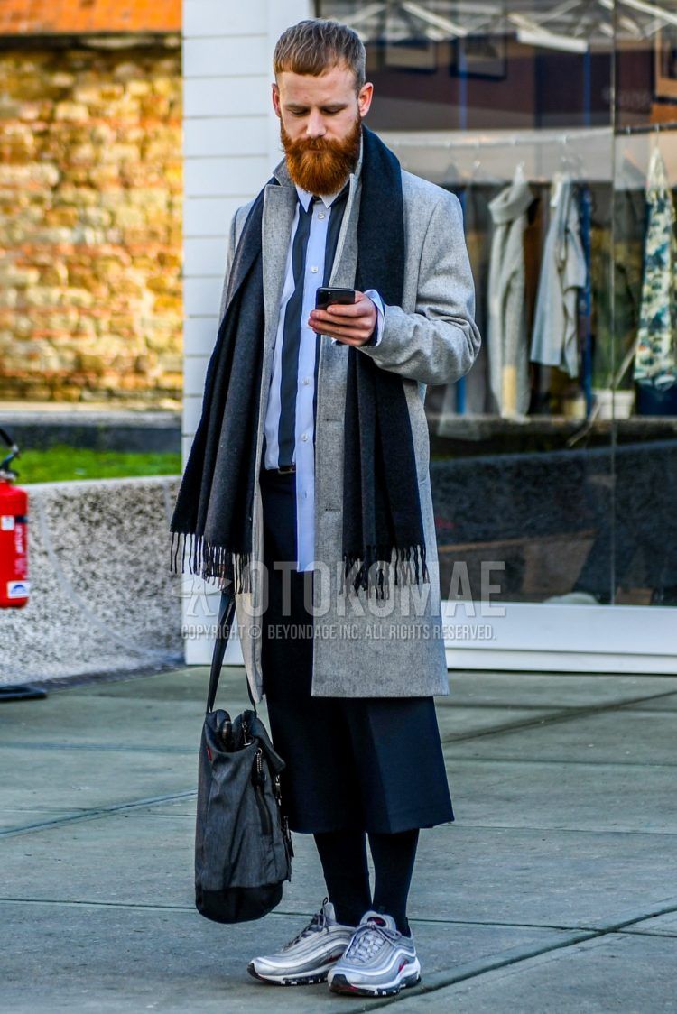 Wearing a plain gray scarf/stall, plain gray chester coat, plain white shirt, plain gray slacks, plain black socks, Nike Air Max 97 gray low-cut sneakers, and a plain gray briefcase/handbag for men in fall/winter.