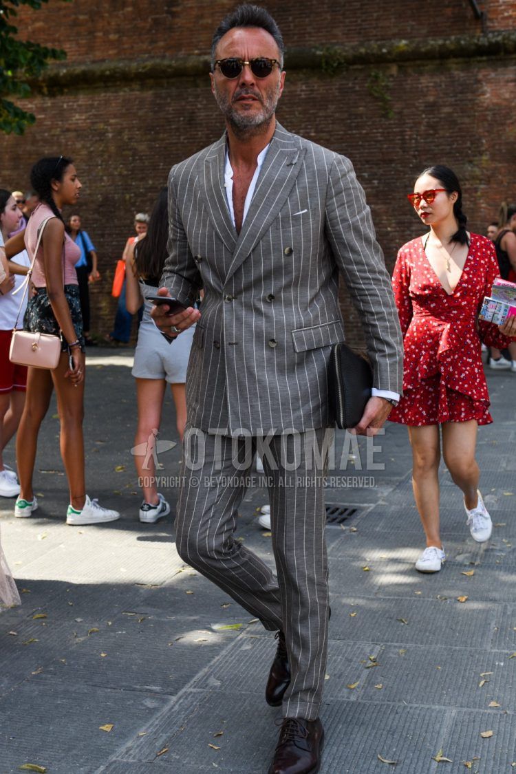 Spring, summer and fall men's coordinate outfit with brown/black tortoiseshell sunglasses, plain white shirt, brown plain toe leather shoes and gray striped suit.