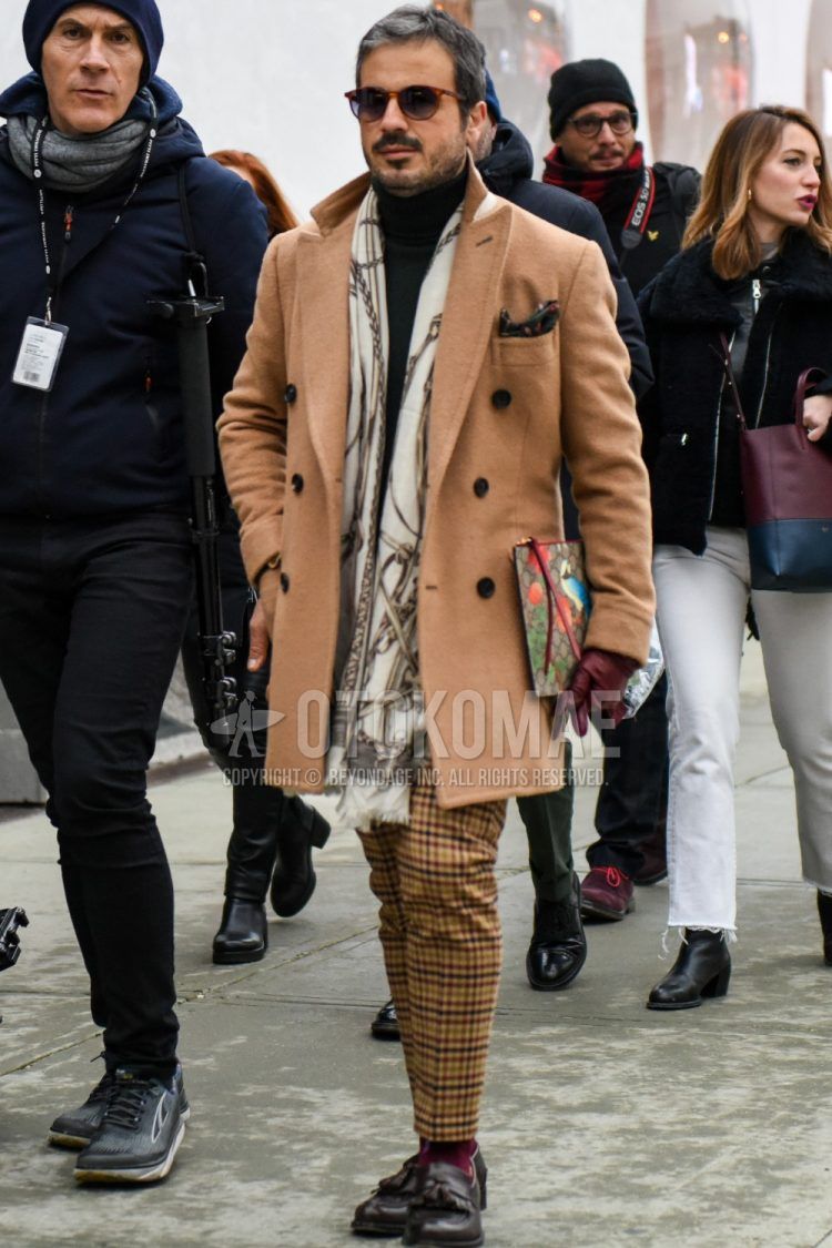 Plain sunglasses, black other scarf/stall, plain beige chester coat, plain black turtleneck knit, brown/beige checked slacks, plain red socks, brown tassel loafer leather shoes, Gucci multicolor checked clutch bag/second bag/drawstring bag with a winter men's outfit.
