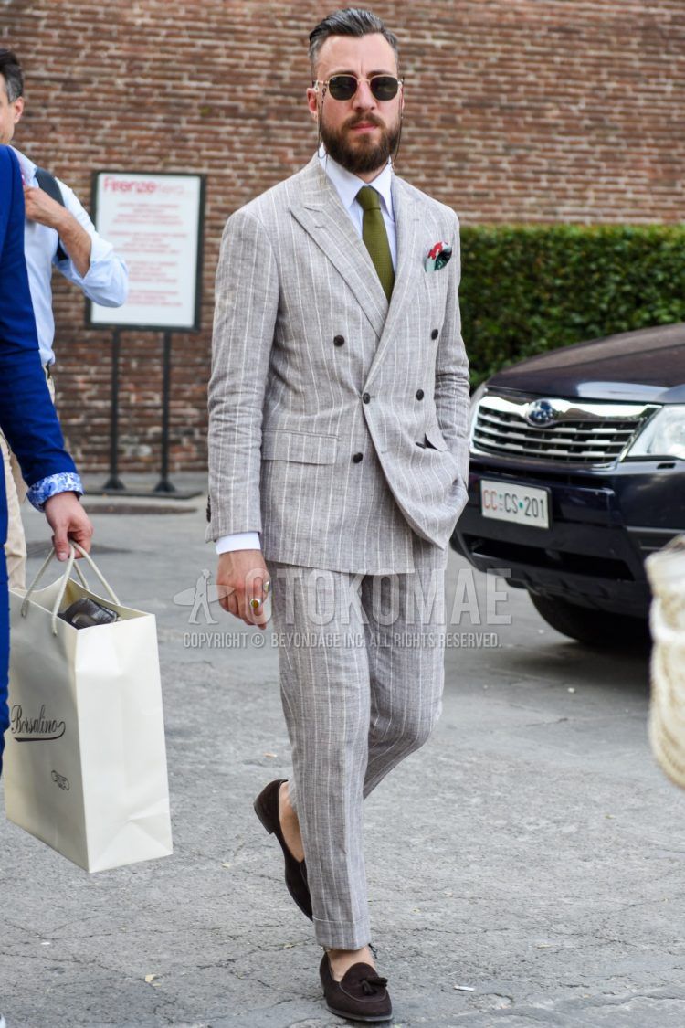 Spring, summer and fall men's coordinate outfit with gold and black plain sunglasses, plain white shirt, brown tassel loafer leather shoes, gray striped suit and olive green plain tie.