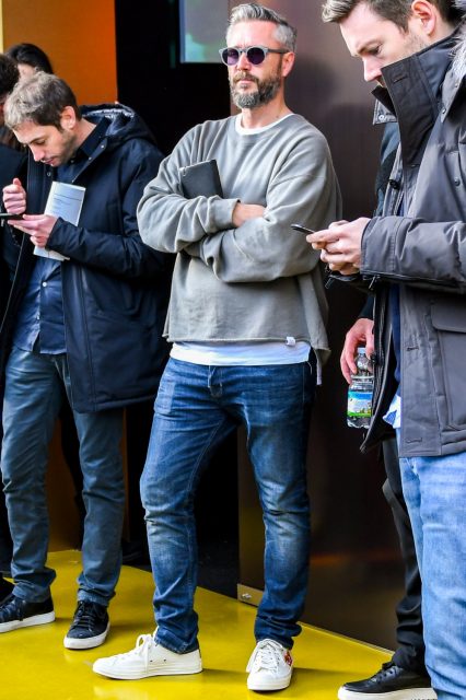 Spring and fall men's oversized coordinate outfit with plain sunglasses, plain gray sweatshirt, plain white t-shirt, plain blue denim/jeans, and white low-cut sneakers by Comme des Garcons Play Converse.