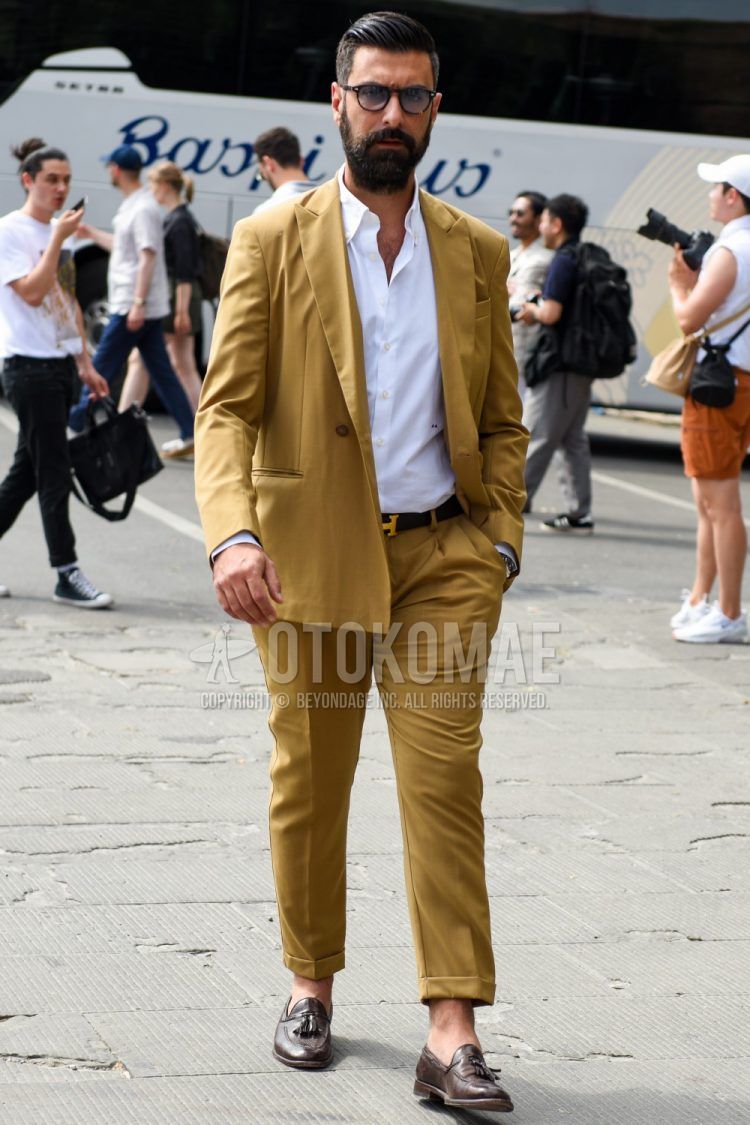 Spring, fall and summer men's coordinate outfit with brown tortoiseshell sunglasses, plain white shirt, plain black Hermes leather belt, brown tassel loafer leather shoes and plain beige suit.
