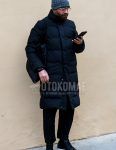 A winter men's outfit with a gray other knit cap, solid color glasses, solid color navy down jacket, solid color black ankle pants, solid color black low cut sneakers, and solid color black tote bag.