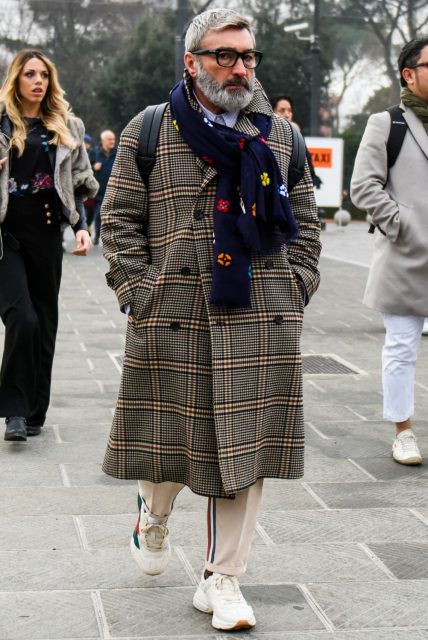 Men's oversized fall/winter coordinate outfit with plain glasses, navy other scarf/stall, beige check chester coat, plain beige sidelined pants, and white low-cut sneakers.