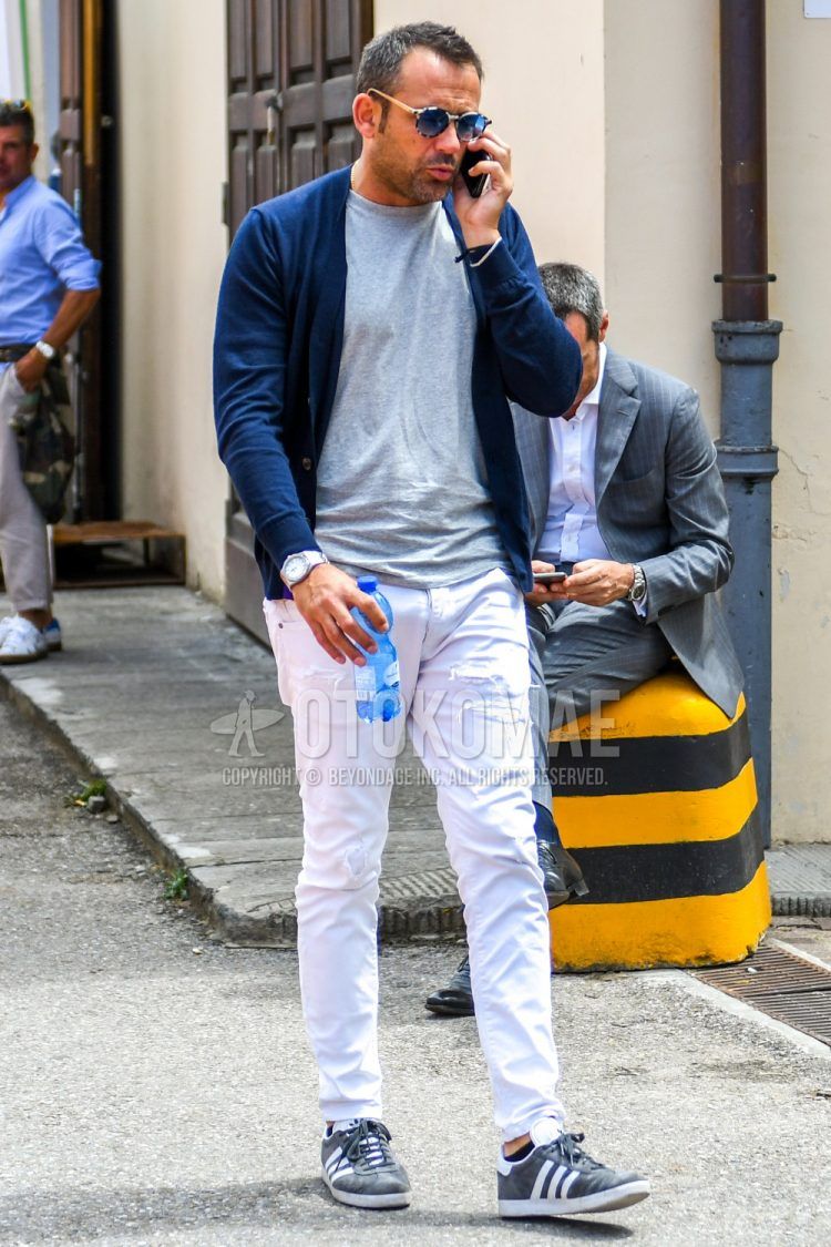 A men's spring/fall/summer coordinate outfit with plain sunglasses, plain navy cardigan, plain gray t-shirt, plain white damaged jeans, and Adidas gray low-cut sneakers.