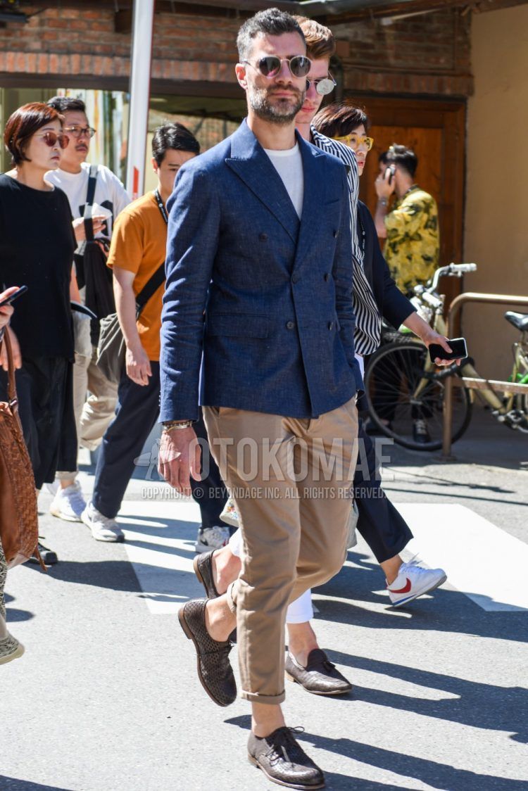 Men's spring/summer outfit with Ray-Ban plain silver/black sunglasses, plain gray tailored jacket, plain white T-shirt, plain beige chinos, and brown plain-toe leather shoes.