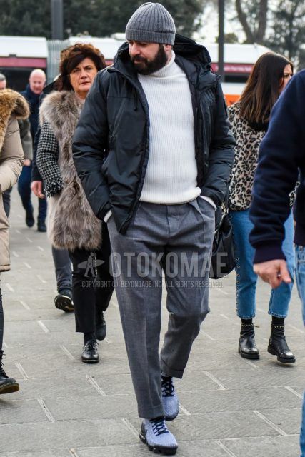 A men's fall/winter outfit with a solid gray knit cap, solid black windbreaker, solid black down jacket, solid white turtleneck knit, solid gray wool pants, and Nike Vapormax gray low-cut sneakers.