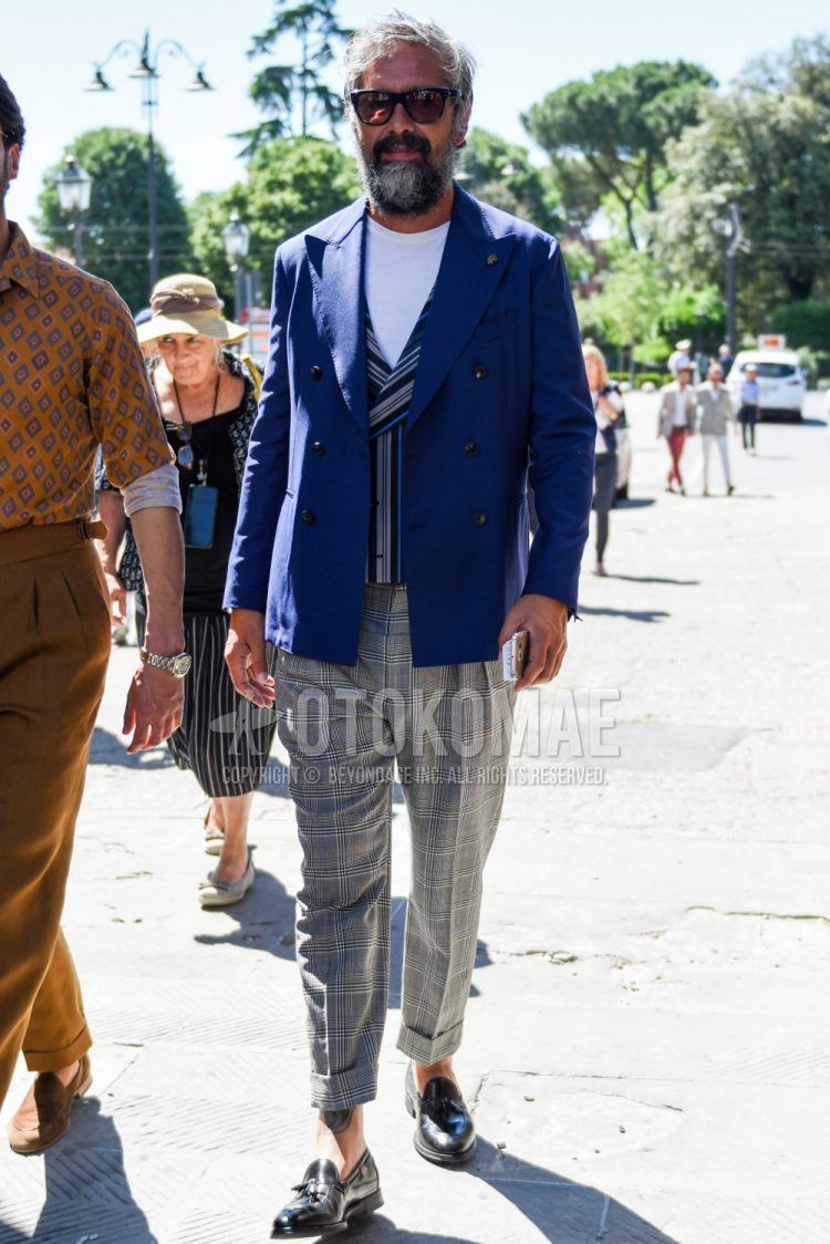 Spring and fall men's coordinate outfit with plain black Wellington sunglasses, plain navy tailored jacket, gray striped gilet, plain white t-shirt, gray checked slacks, and black tassel loafer leather shoes.