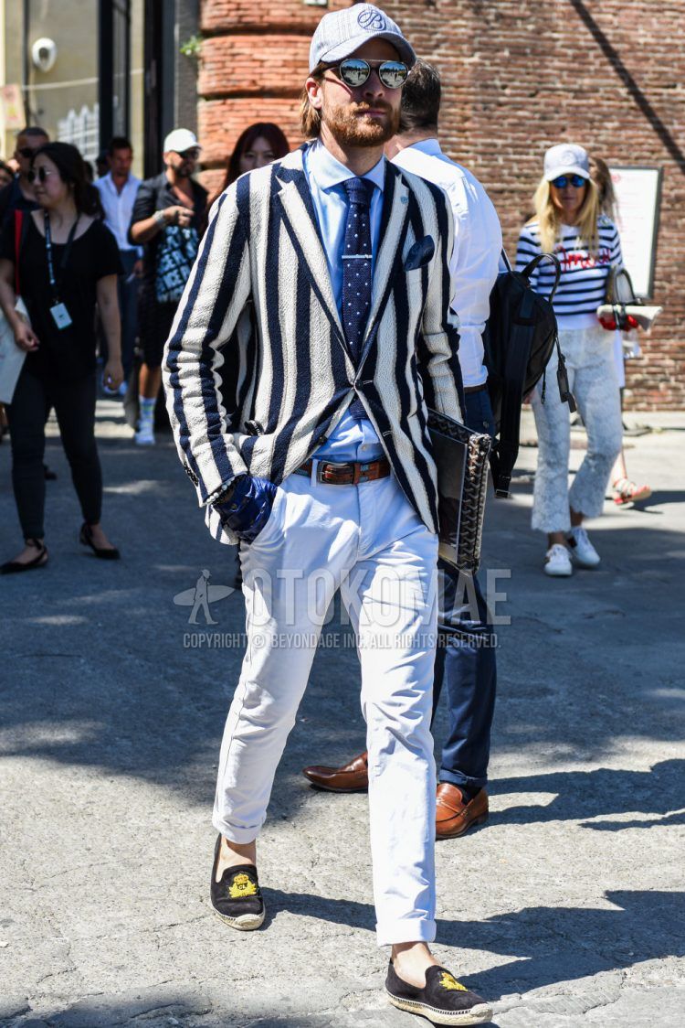 Gray one-pointed baseball cap, navy/white striped tailored jacket, solid light blue shirt, multi-colored other mesh belt, solid white cotton pants, white espadrilles, solid brown Goyard clutch/second bag/drawstring, Spring/Summer/Fall men's coordinate outfit with navy dot bow tie.