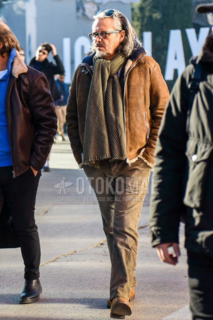 Winter men's outfit with plain glasses, brown dotted scarf/stall, plain brown leather jacket (other than rider's), plain brown cotton pants, brown other boots.