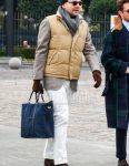 Men's outfit with brown tortoiseshell sunglasses, solid gray scarf/stall, solid beige down jacket, beige checked tailored jacket, solid white denim/jeans, suede brown chukka boots, solid navy briefcase/handbag. Outfit.