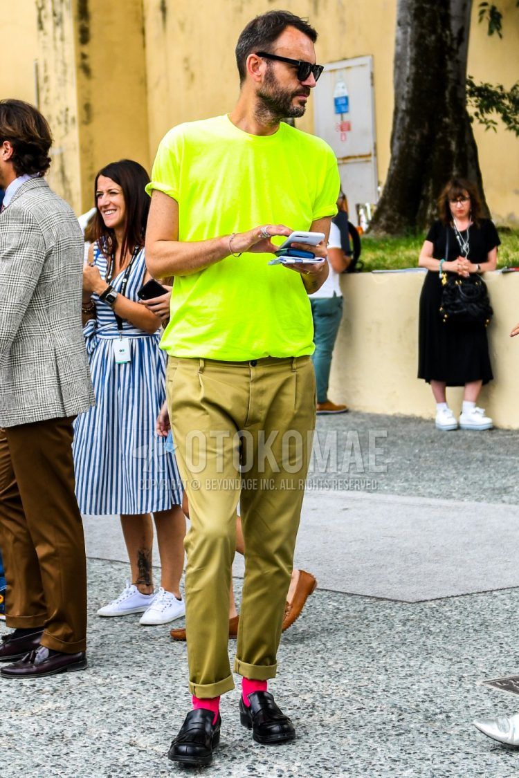 Men's coordinate and outfit with plain sunglasses, plain yellow t-shirt, plain beige chinos, plain red socks, and black coin loafer leather shoes.