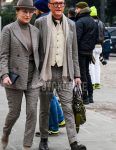 A winter men's outfit with plain glasses, plain beige scarf/stall, plain white gilet, plain brown shirt, brown country boots, gray checked suit, and plain beige tie.