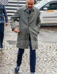 A winter men's outfit with a plain gray stainless steel collar coat, a plain navy sweater, plain navy slacks, and navy low-cut sneakers.