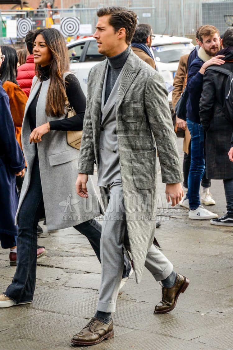 Fall/winter men's outfit with glen check gray check chester coat, plain gray turtleneck knit, plain gray socks, brown wingtip leather shoes, and plain gray suit.