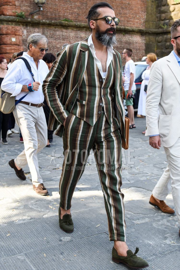 Spring, summer and fall men's coordinate outfit with plain black sunglasses, plain white shirt, green tassel loafer leather shoes and multi-colored striped three-piece suit.