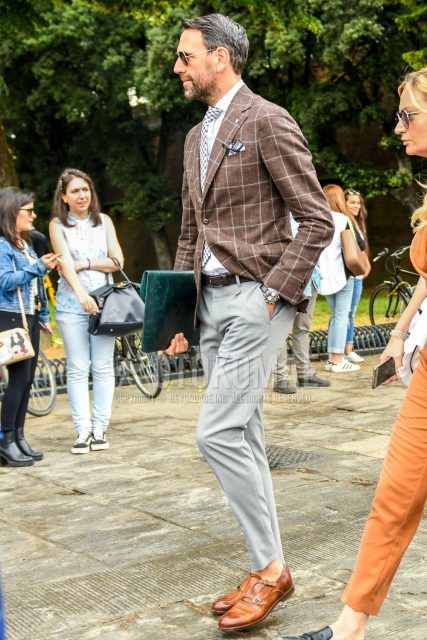 Gold plain sunglasses, brown checked tailored jacket, white plain shirt, brown plain leather belt, gray plain slacks, beige monk shoes leather shoes, green plain clutch bag/second bag/drawstring, black and white tie Men's Codes and Outfits.
