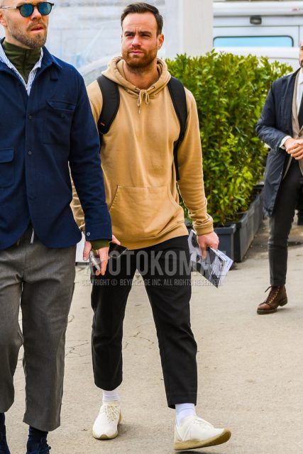 Men's coordinate and outfit with plain beige hoodie, plain gray slacks, plain white socks, and white low-cut sneakers.
