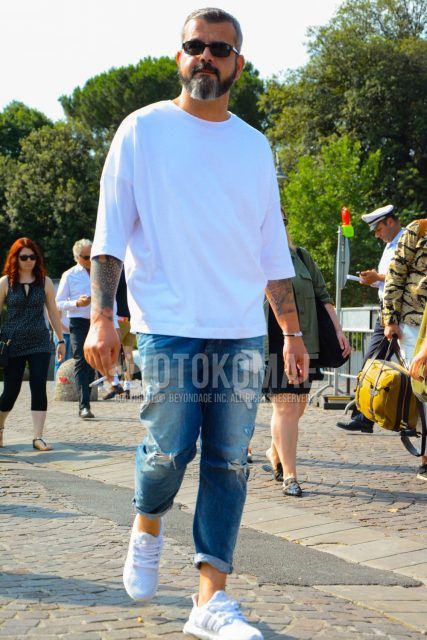 Men's coordinate and outfit with plain sunglasses, plain white long T, plain blue damaged jeans, and white low-cut Adidas sneakers.