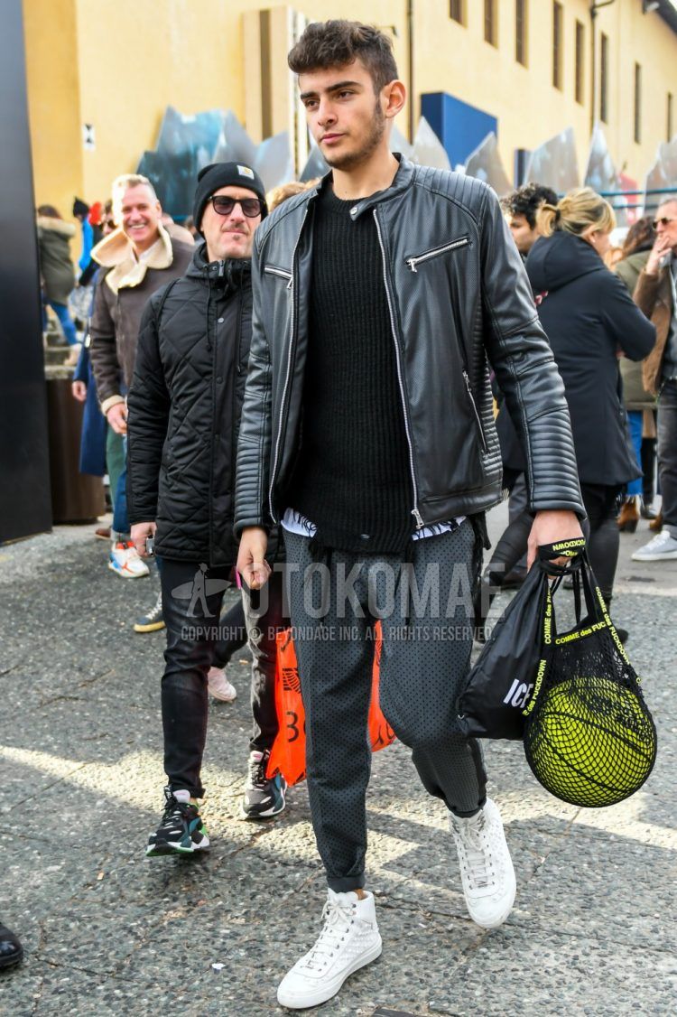 Fall and spring men's coordinate outfit with plain black rider's jacket, plain black sweater, plain white t-shirt, gray other easy pants, and white high-cut sneakers.