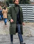 A winter men's outfit of a plain olive green stainless steel collar coat, a plain olive green turtleneck knit, black side gore boots, and a dark gray solid color suit.