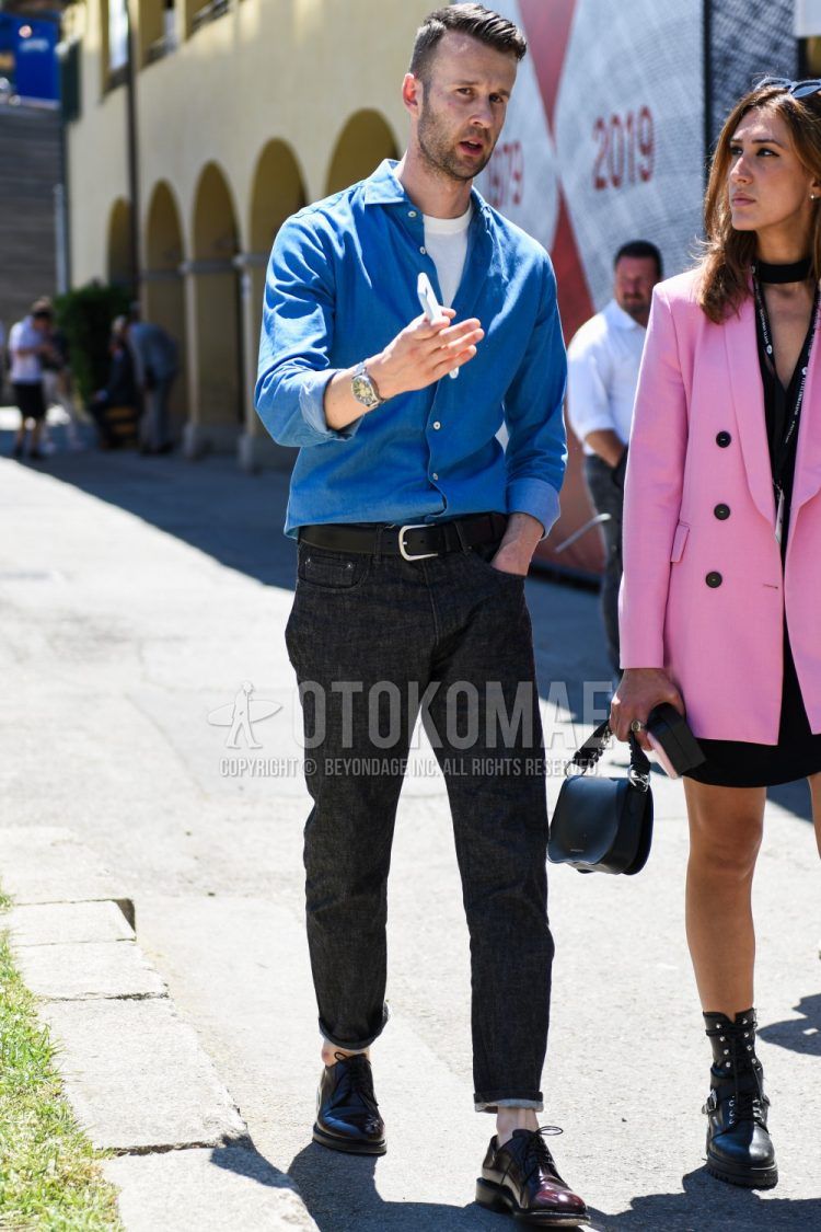 Men's coordinate and outfit with plain blue shirt, plain white t-shirt, plain black leather belt, plain black denim/jeans, and brown straight tip leather shoes.