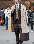 Winter men's outfit with plain beige chester coat, plain beige gilet, plain white shirt, brown straight tip leather shoes, plain brown tote bag, plain brown suit and brown other tie.