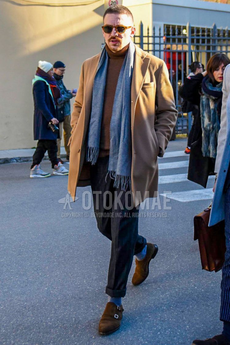 Fall and winter men's coordinate outfit with brown tortoiseshell sunglasses, solid gray scarf/stall, solid beige chester coat, solid brown turtleneck knit, gray striped slacks, solid gray socks, suede brown monk shoes leather shoes.