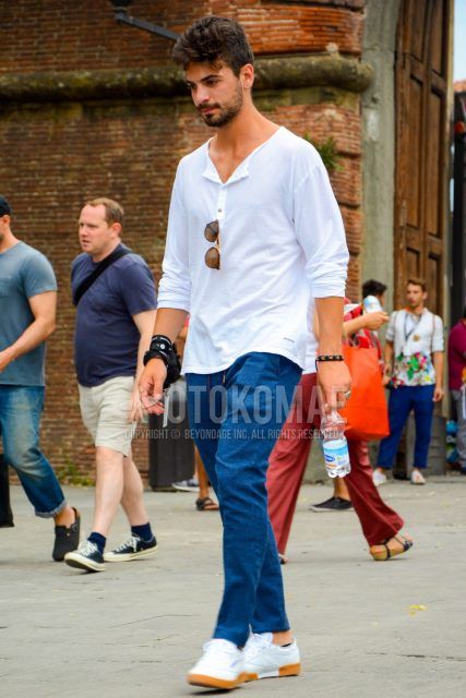 Men's coordinate and outfit with plain white long T with henley neck, plain blue easy pants, and white low-cut sneakers.
